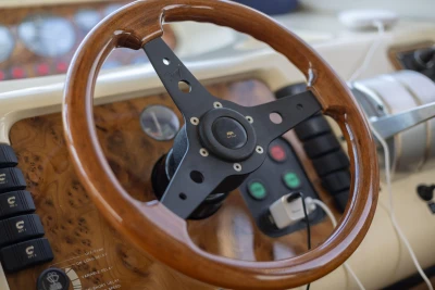 Wooden steering wheel on a 1995 Princess 60 yacht dashboard.