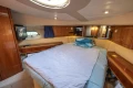 Luxurious cabin interior of 1995 Princess 60 yacht with cozy bed and wooden furnishings.