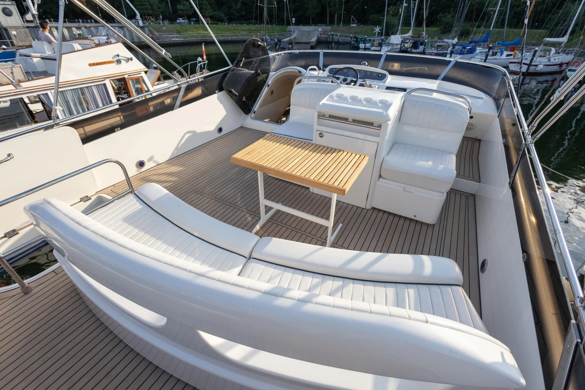 Luxurious 1995 Princess 60 yacht deck with white seating and wooden table.
