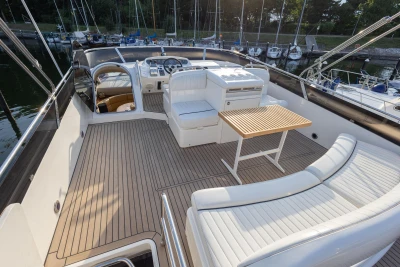 Luxurious 1995 Princess 60 yacht deck with seating and table, docked at marina.