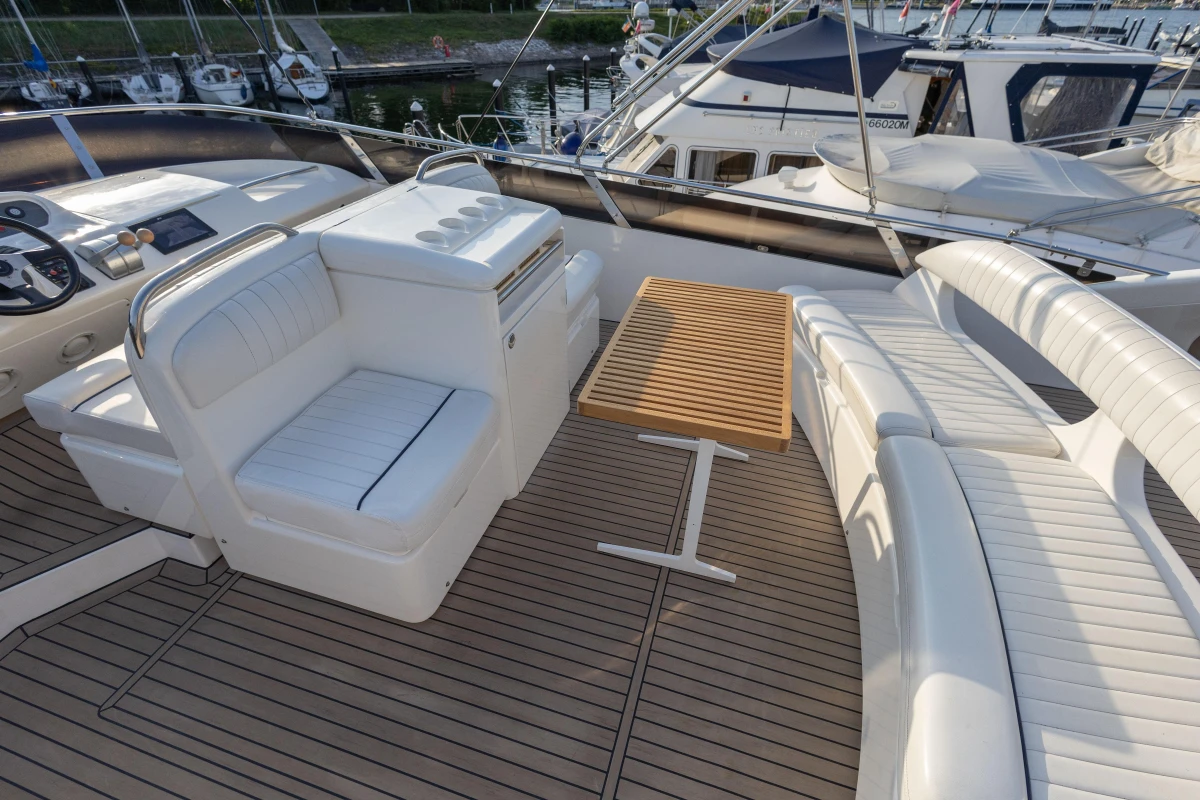 Luxurious 1995 Princess 60 yacht deck with white seating and wooden table.