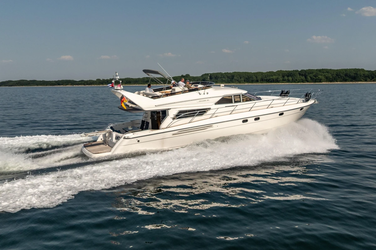 Luxury 1995 Princess 60 yacht cruising on open water, clear sky background.