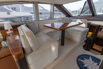 Luxurious interior of a 2012 Princess 50 yacht with elegant seating and wooden table.