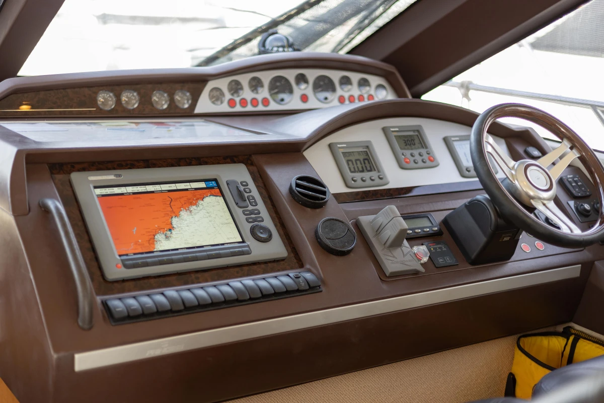 Control panel of a 2012 Princess 50 yacht with navigation equipment and steering wheel.