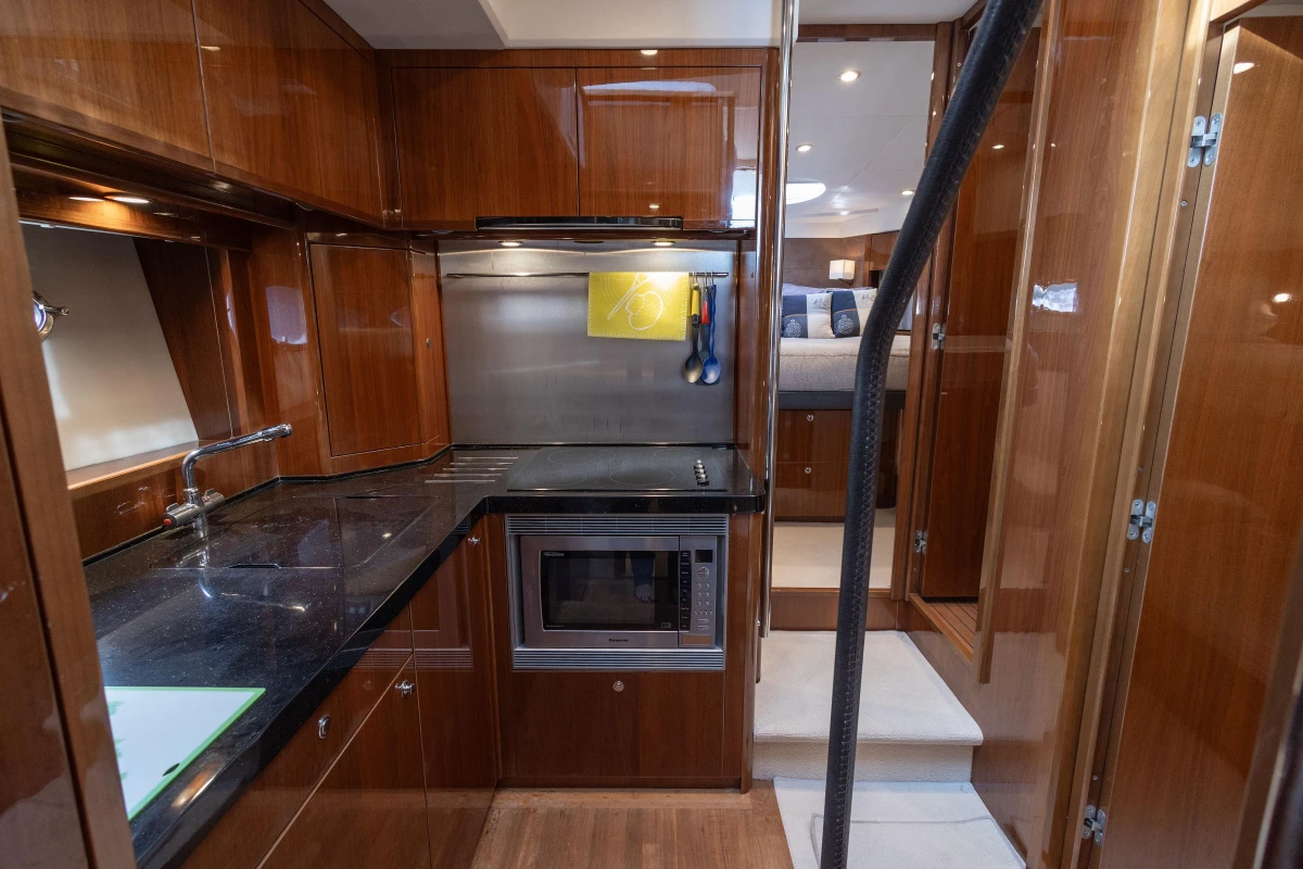 Luxurious kitchen interior of 2012 Princess 50 yacht with modern appliances and wood finish.