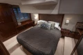Luxurious bedroom interior of 2012 Princess 50 yacht with elegant bedding and wood accents.