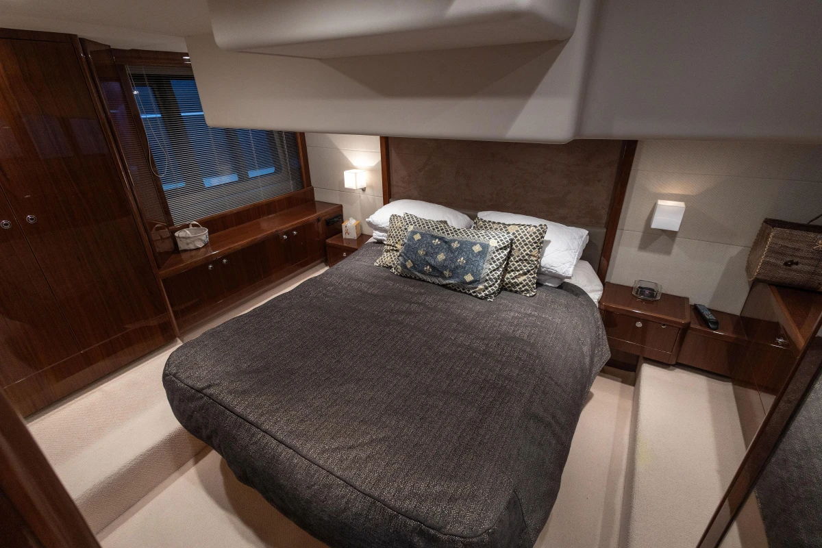 Luxurious bedroom interior of 2012 Princess 50 yacht with elegant bedding and wood accents.