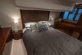 Luxurious bedroom interior of 2012 Princess 50 yacht with elegant bedding and wooden accents.