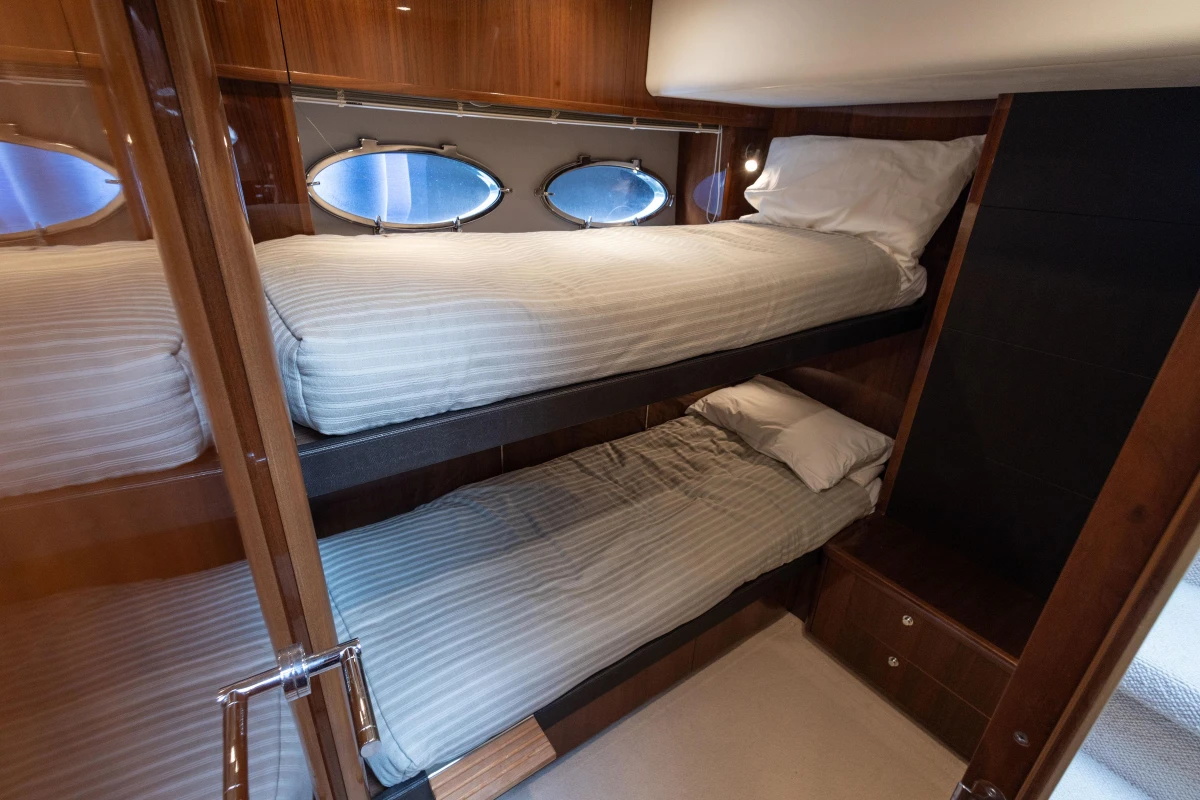 Luxurious 2012 Princess 50 yacht cabin with cozy bunk beds and elegant wood finish.