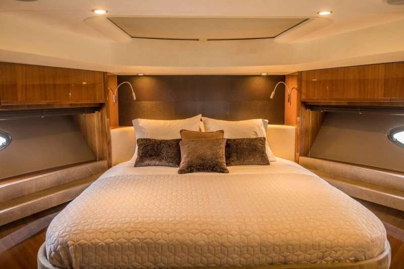 Luxurious bedroom interior of 2013 Princess 72 Motor Yacht with elegant bedding and wood accents.