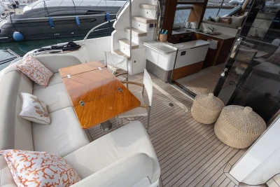Luxurious 2020 Princess F62 yacht interior with elegant seating, wooden table, and modern kitchen area.