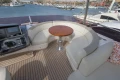 Luxurious 2020 Princess F62 yacht deck with seating and table, overlooking marina.