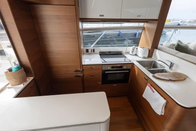 Modern kitchen interior on 2020 Princess F62 yacht with wood cabinetry and appliances.