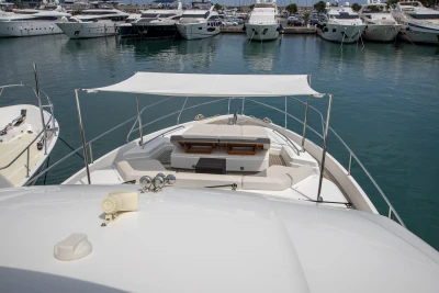 View from a boat showing the deck with sunshade, surrounded by other yachts in the marina.
