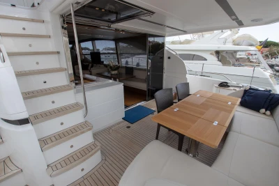 2016 Princess 68: Luxurious outdoor area with dining table and stairs, perfect for relaxation.