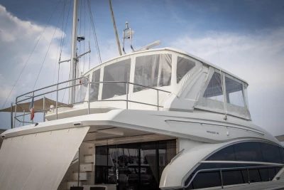 A luxury yacht with an enclosed upper deck and sleek lines.