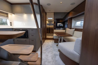 Luxurious interior of 2025 Princess V50 yacht with modern kitchen and cozy seating area.