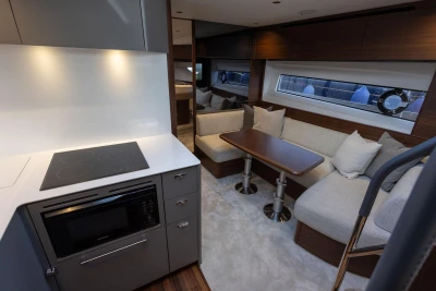 Luxurious interior of 2025 Princess V50 yacht with modern kitchen and cozy seating area.