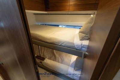 Bunk beds in 2026 Princess S65 yacht cabin, featuring wooden finishes and cozy bedding.