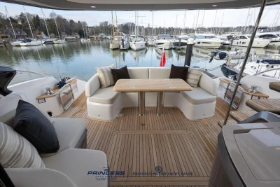 Luxurious 2026 Princess S65 yacht deck with elegant seating and scenic marina view.