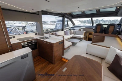 Luxurious interior of 2026 Princess S65 yacht with modern kitchen and seating area.