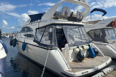 2004 Princess 45 Flybridge Motor Yacht docked at marina under blue sky.