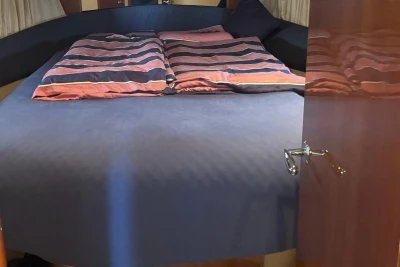 Luxurious cabin interior of 2004 Princess 45 Flybridge Motor Yacht with striped bedding.