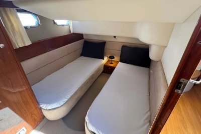 Interior cabin of 2006 Princess 42 yacht with twin beds and cozy decor.