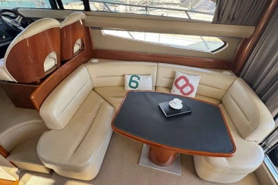 Luxurious 2006 Princess 42 yacht interior with cream leather seating and elegant dining table.