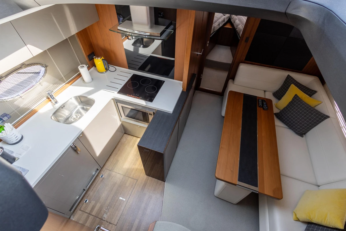 Luxurious interior of 2014 Princess V52 yacht with modern kitchen and cozy seating area.