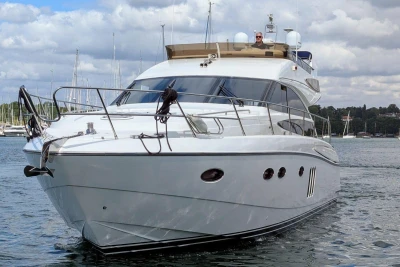 Luxury 2009 Princess 54 yacht cruising on a calm waterway under a cloudy sky.