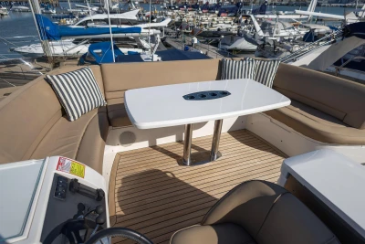 Luxurious seating area on 2009 Princess 54 yacht with table and striped cushions.