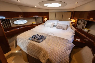 Luxurious bedroom interior of 2009 Princess 54 yacht with elegant bedding and ambient lighting.