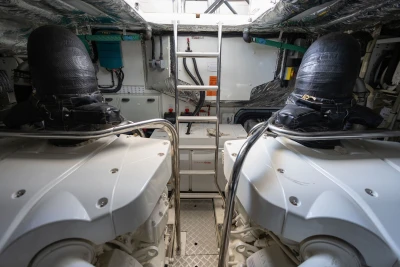 Engine room of a 2018 Princess S60 yacht, featuring dual engines and a central ladder.