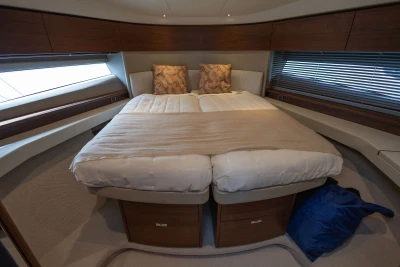 Luxurious bedroom interior of 2023 Princess F45 yacht with elegant bedding and wood accents.