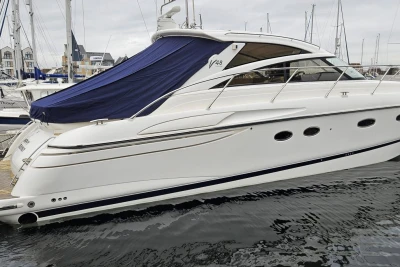 2006 Princess V48 yacht docked in marina, featuring sleek design and blue cover.