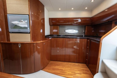 Luxurious 2006 Princess V48 yacht interior with polished wood cabinetry and modern amenities.