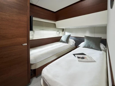 Luxurious twin cabin in 2025 Princess F65 yacht with modern decor and cozy bedding.