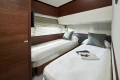 Luxurious twin cabin in 2025 Princess F65 yacht with modern decor and cozy bedding.