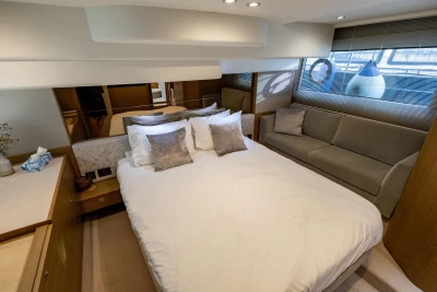 Luxurious bedroom interior of 2018 Princess 49 yacht with elegant furnishings and soft lighting.
