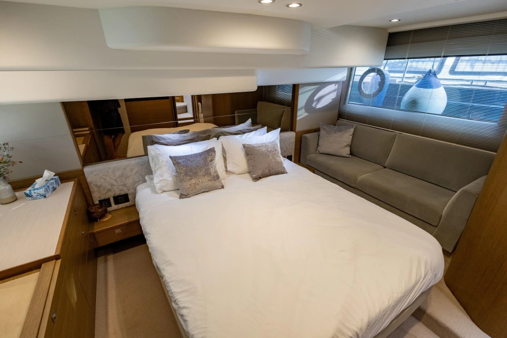Luxurious bedroom interior of 2018 Princess 49 yacht with elegant furnishings and soft lighting.