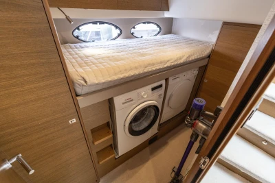 Laundry area with washer, dryer, and vacuum in 2018 Princess 49 yacht cabin.