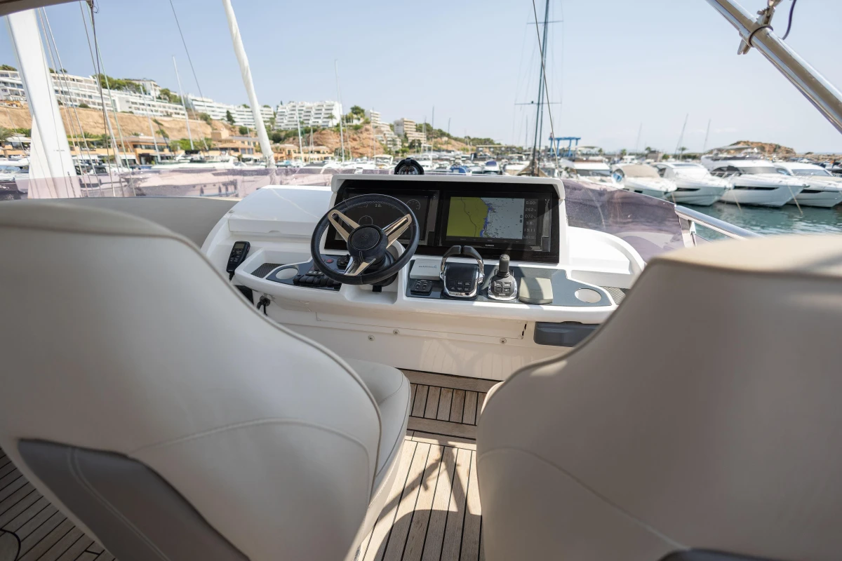 Helm of 2018 Princess 49 yacht with navigation equipment in marina setting.
