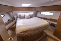 Luxurious cabin interior of 2018 Princess 49 yacht with cozy bed and elegant decor.