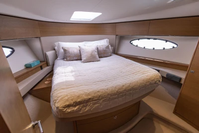 Luxurious cabin interior of 2018 Princess 49 yacht with cozy bed and elegant decor.