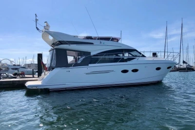Luxury 2017 Princess 43 yacht docked in a sunny marina setting.