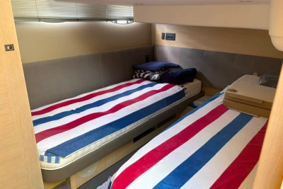 Twin beds with striped bedding in a 2017 Princess 43 yacht cabin.