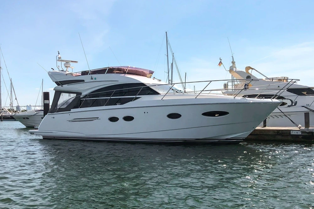 Luxury 2017 Princess 43 yacht docked in marina under clear blue sky.