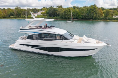 2025 Princess F58 yacht on serene water with lush green shoreline.