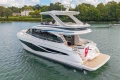 Luxurious 2025 Princess F58 yacht cruising on a serene river with lush greenery.